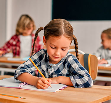 Student writing in her notebook in class